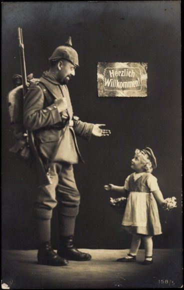 Маленькая девочка стоит рядом с соладтом, которая приветвует его, добро пожаловать!